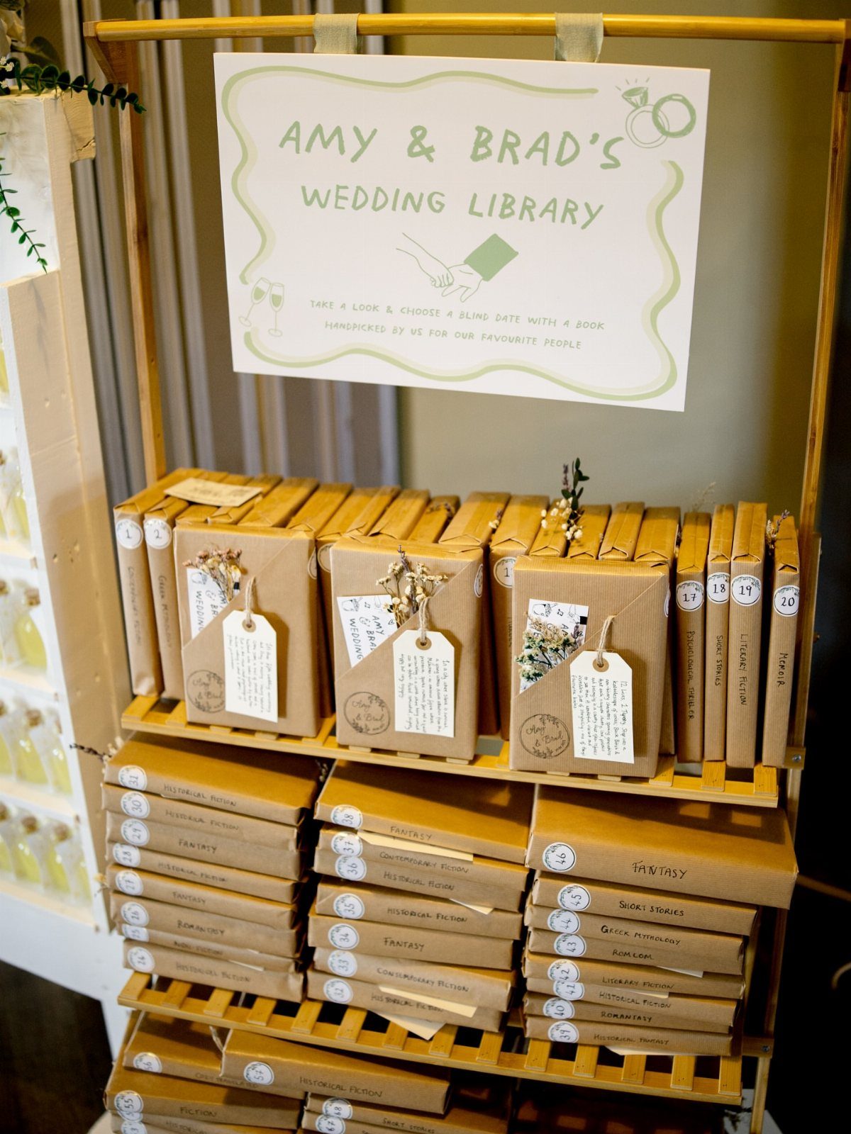 Brown paper-wrapped books with tags on a wooden shelf for a wedding library.