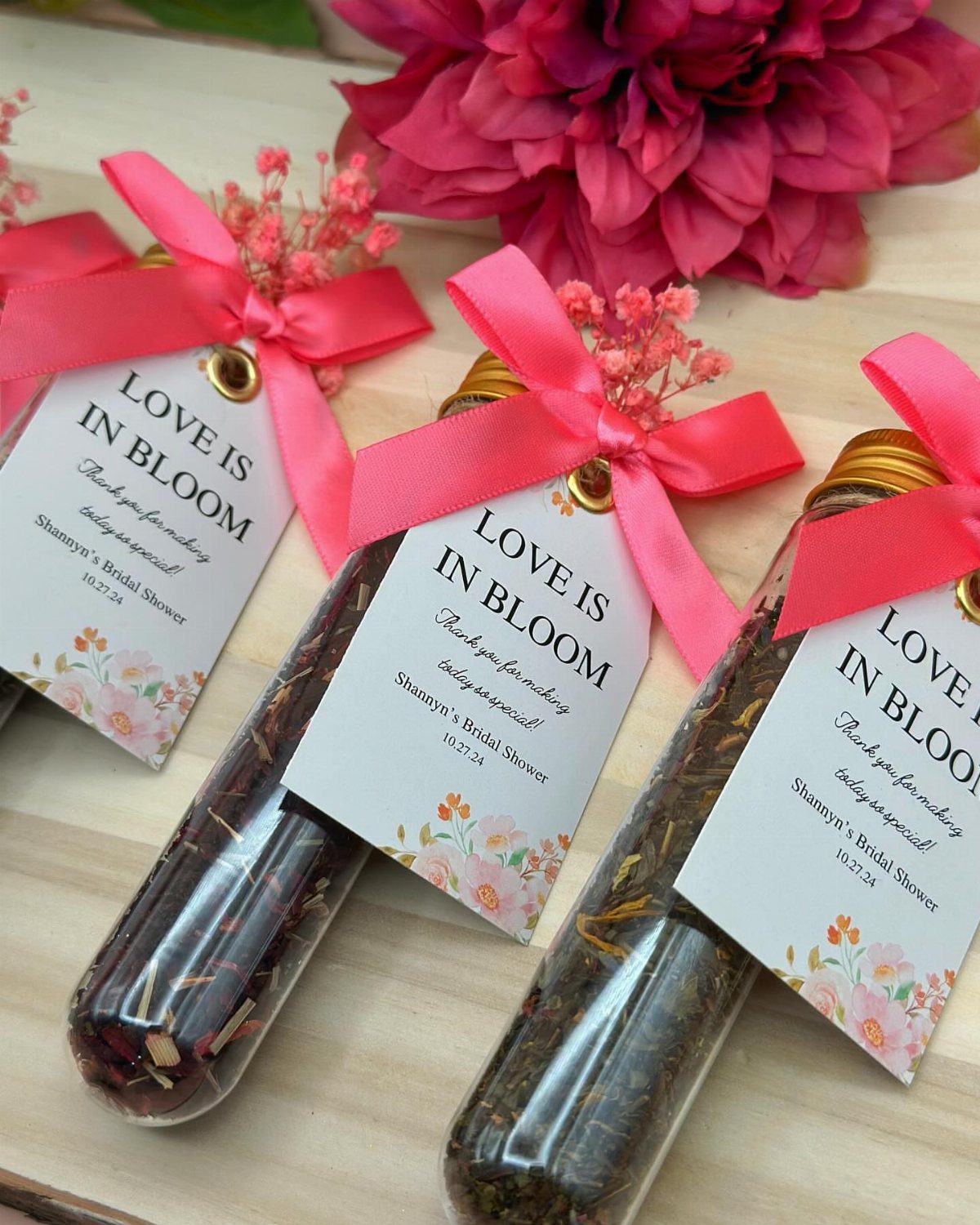 Mini glass tea jars with pink ribbons and bridal shower gift tags.