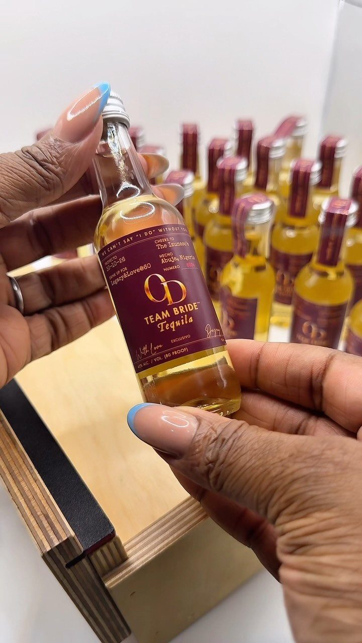 Mini tequila bottles with Team Bride labels held by hands at a party.