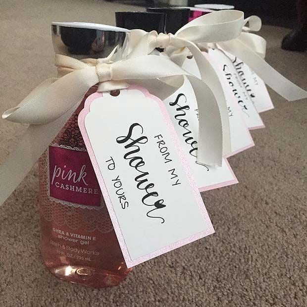 Pink shower gel bottles with white ribbons and personalized shower-themed gift tags.