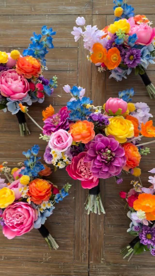 Vibrant floral bouquets with pink, orange, and blue flowers on a wooden background.