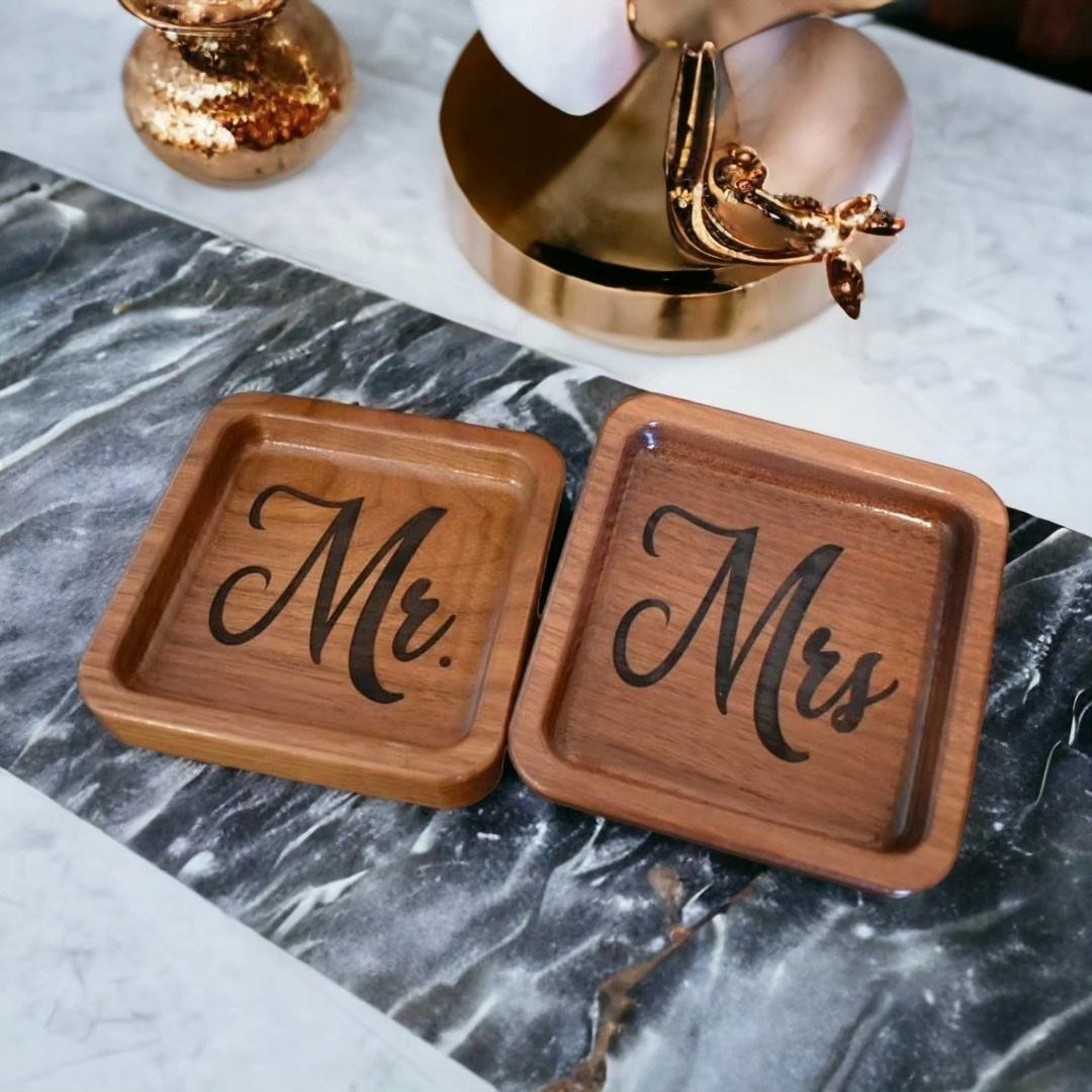 Two wooden catchall trays engraved with Mr. and Mrs. on a marble surface