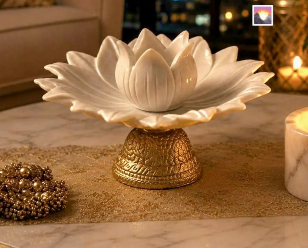 White ceramic lotus bowl on a gold pedestal base on a marble table
