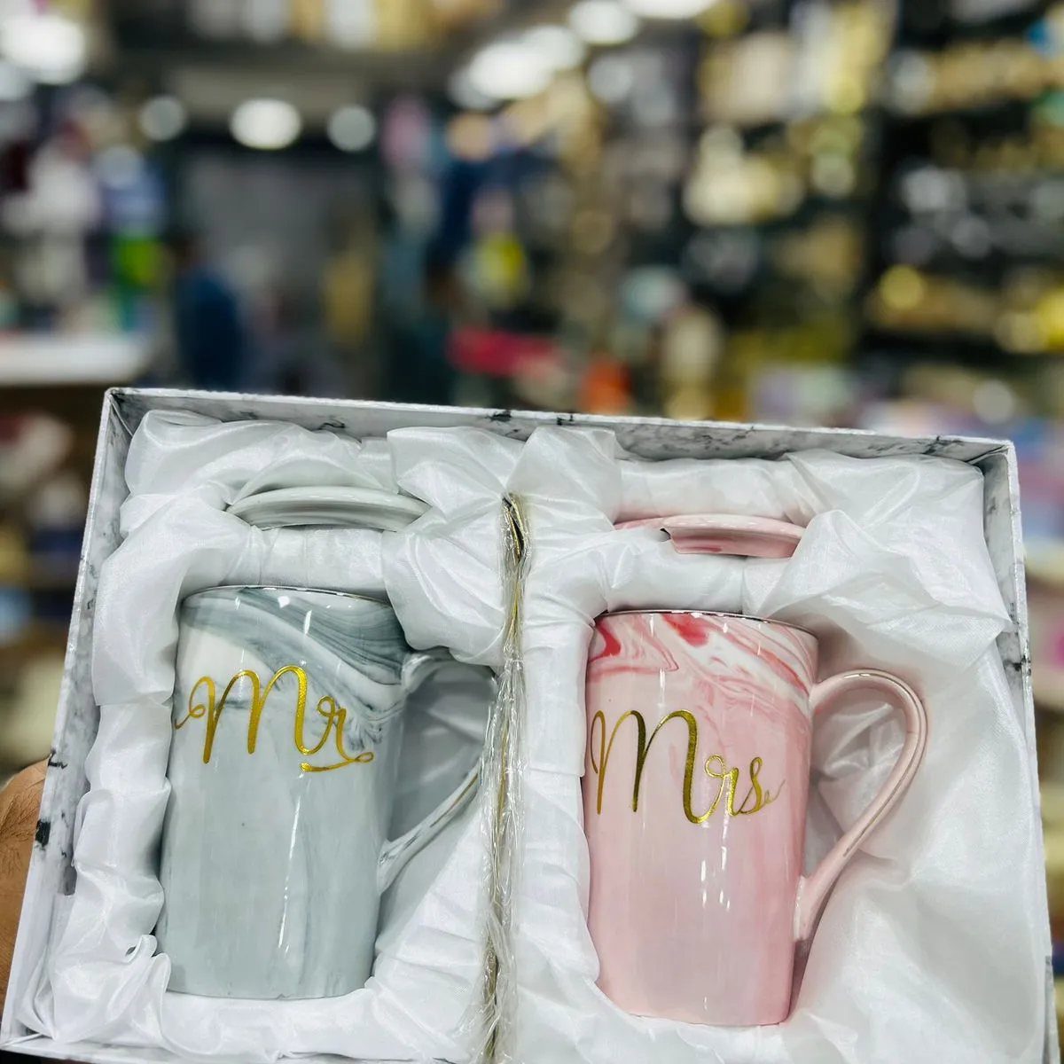 Two marbled ceramic mugs labeled Mr and Mrs in gold script inside a gift box.