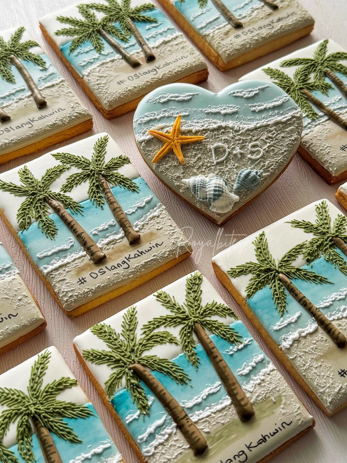 Iced sugar cookies decorated with beach scenes, palm trees, and a heart with starfish.