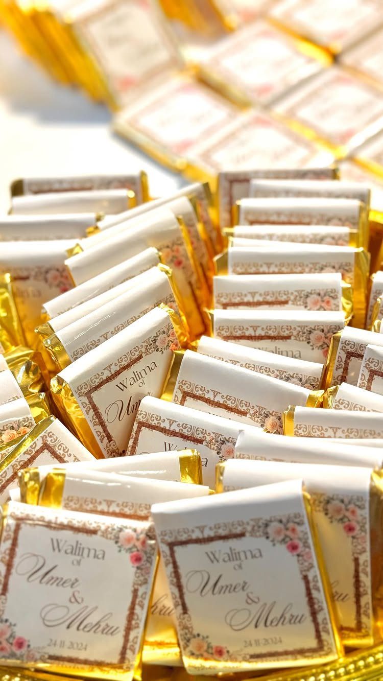 Custom wrapped gold foil chocolate bars with floral labels for a wedding celebration.