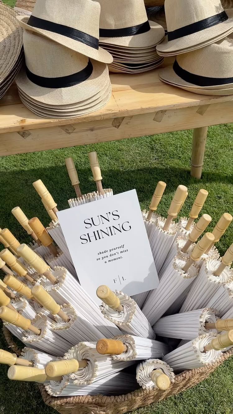 White folded parasols in a wicker basket with straw hats on a table