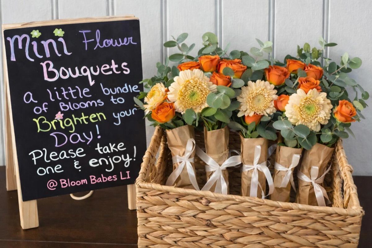 Mini flower bouquets in brown paper wraps arranged in a woven wicker basket.