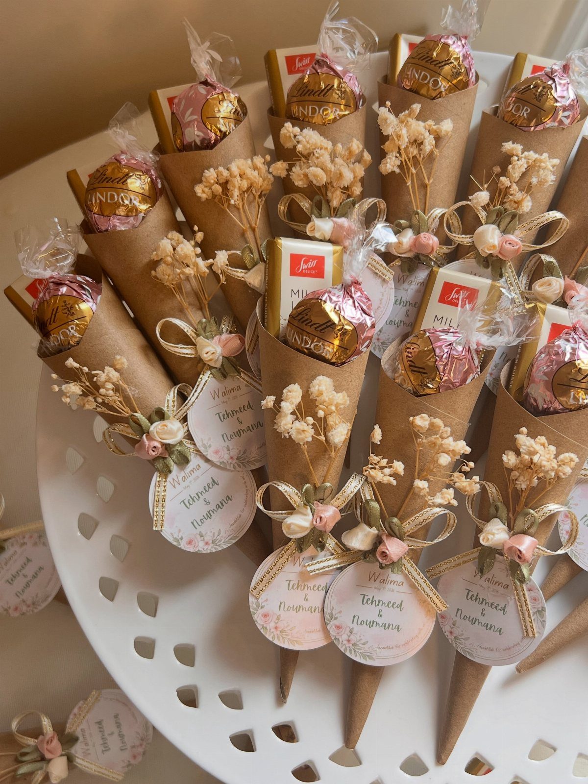 Brown paper cones filled with chocolates and dried flowers with personalized name tags.