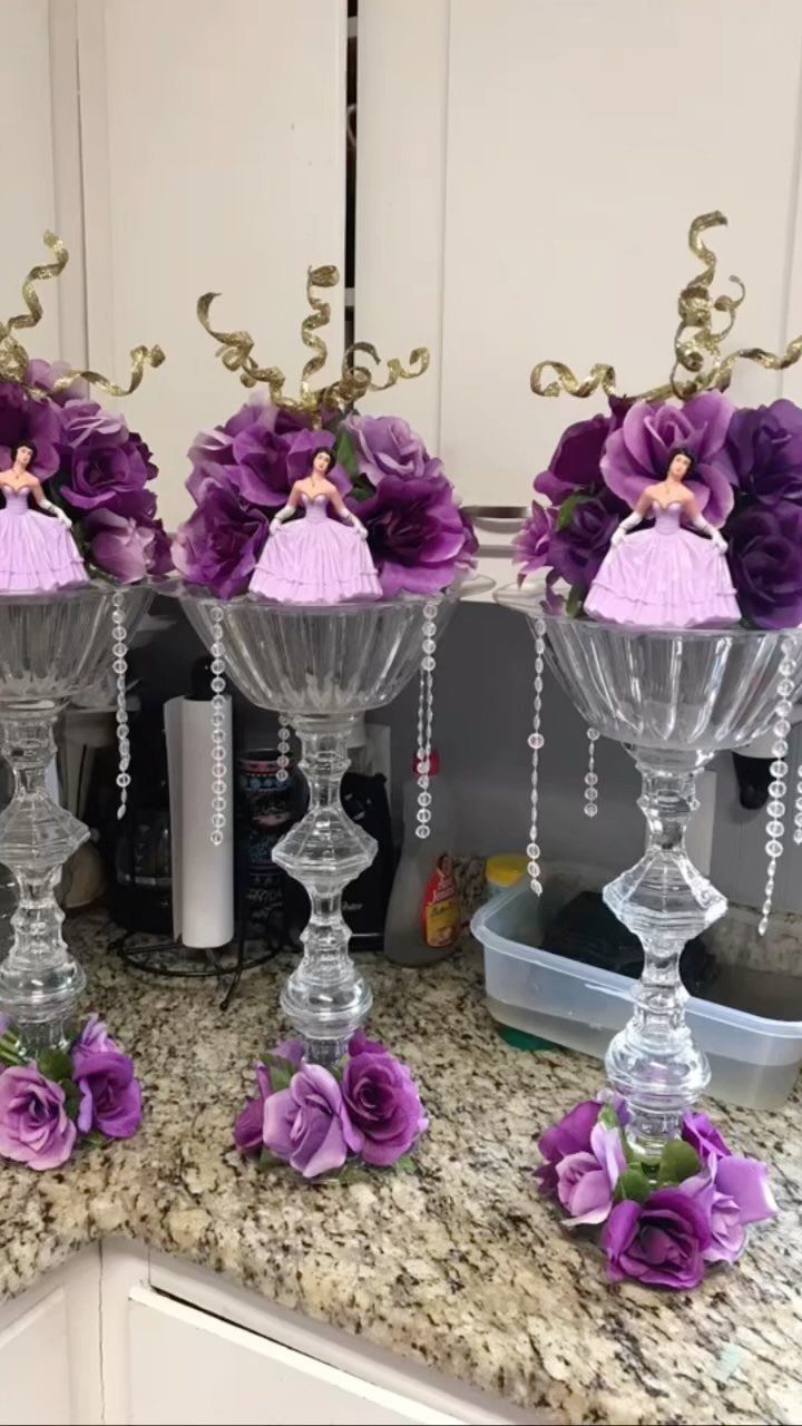 Glass pedestal vases with purple roses, figurines, and hanging crystal bead strands.