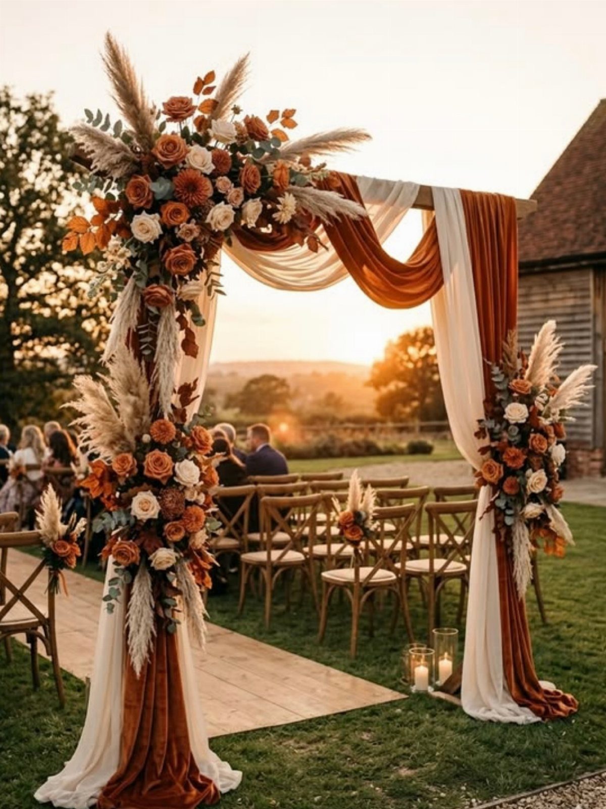 Wooden wedding arch with burnt orange and cream floral arrangements at sunset.
