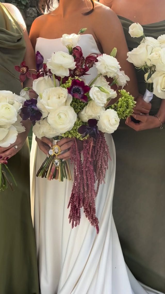 Bride in ivory gown holding burgundy and white bouquet with olive green bridesmaids