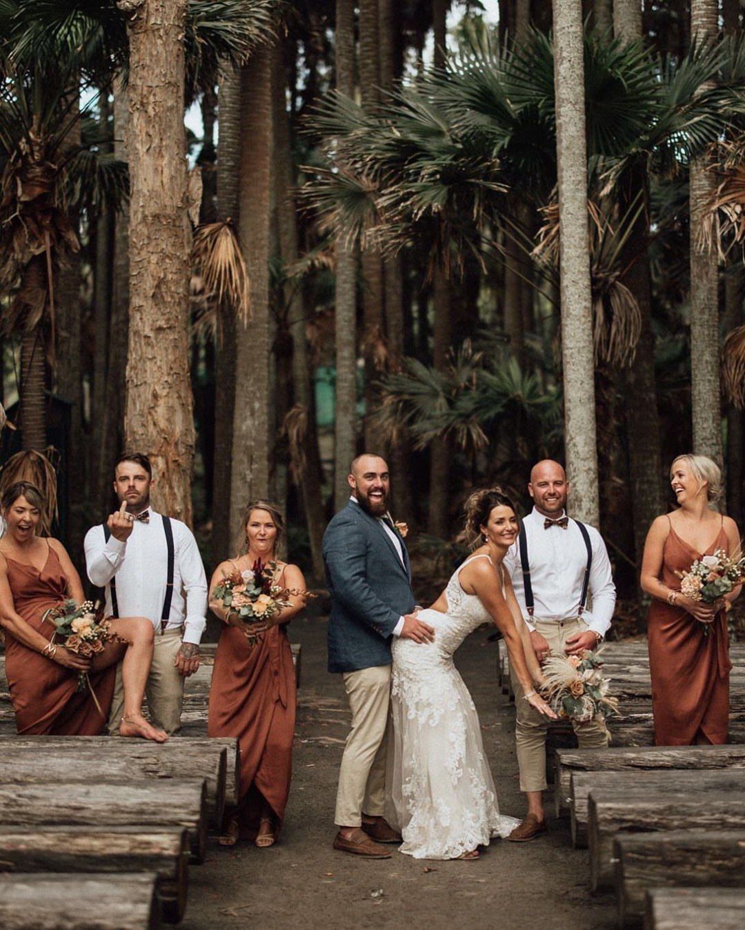 Wedding party in a palm forest with navy blue and terracotta color palette.