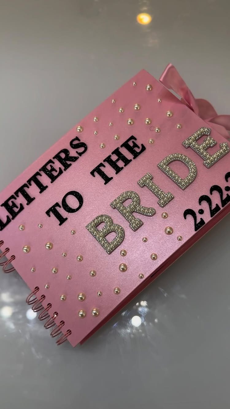 Pink spiral guestbook with pearls and glitter text reading Letters to the Bride
