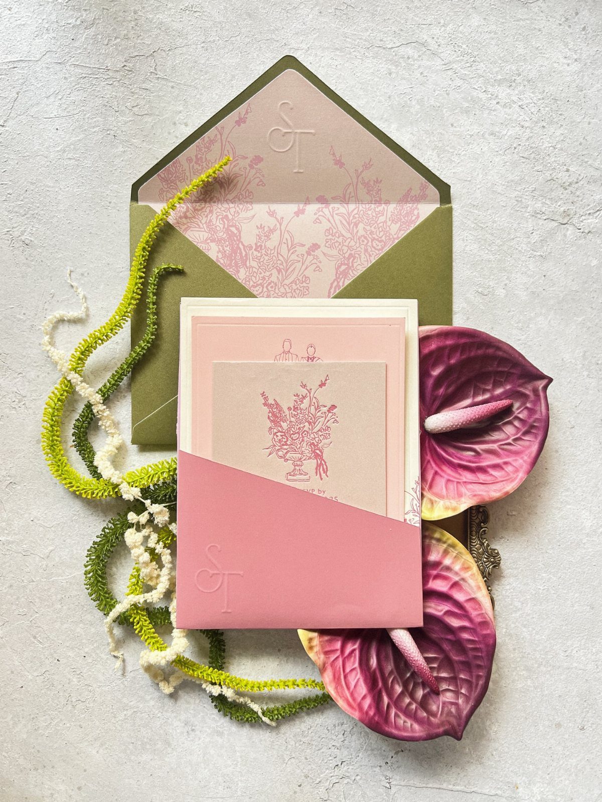 Wedding invitation suite with sage green and pink stationery and purple anthurium flowers.