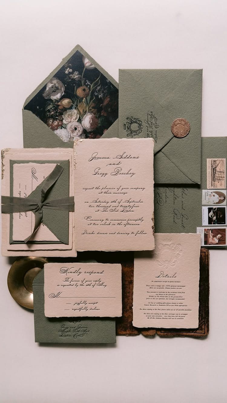 Wedding invitation suite with cream cards, sage green envelopes, and floral accents.