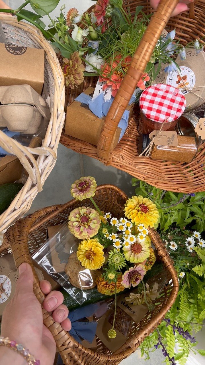 Woven gift baskets filled with brown paper packages and fresh yellow flowers.