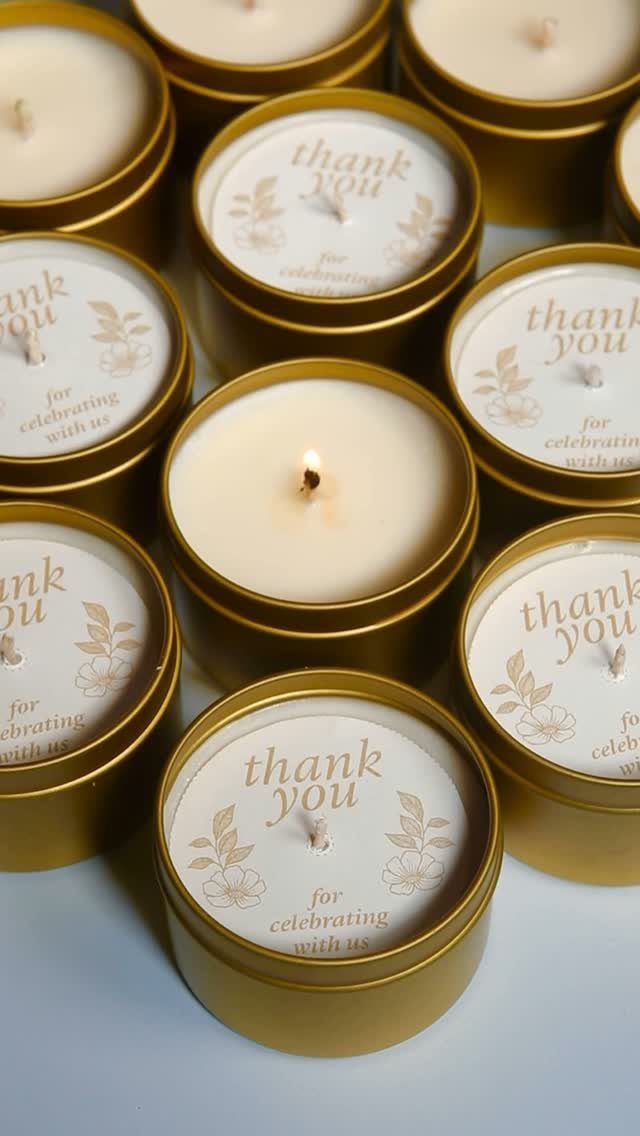 Small gold tin candles with white wax and thank you labels for wedding favors.