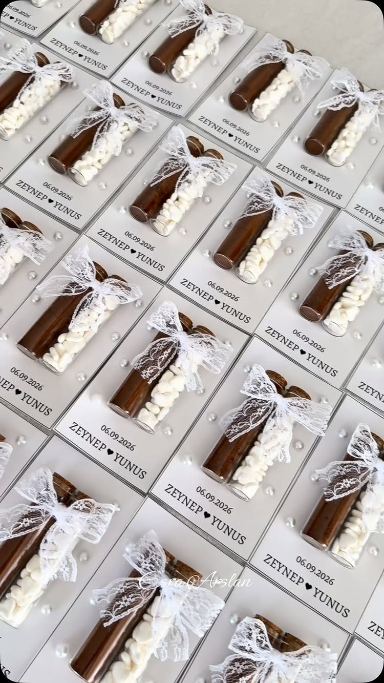 Chocolate sticks tied with lace bows on personalized white wedding favor cards.