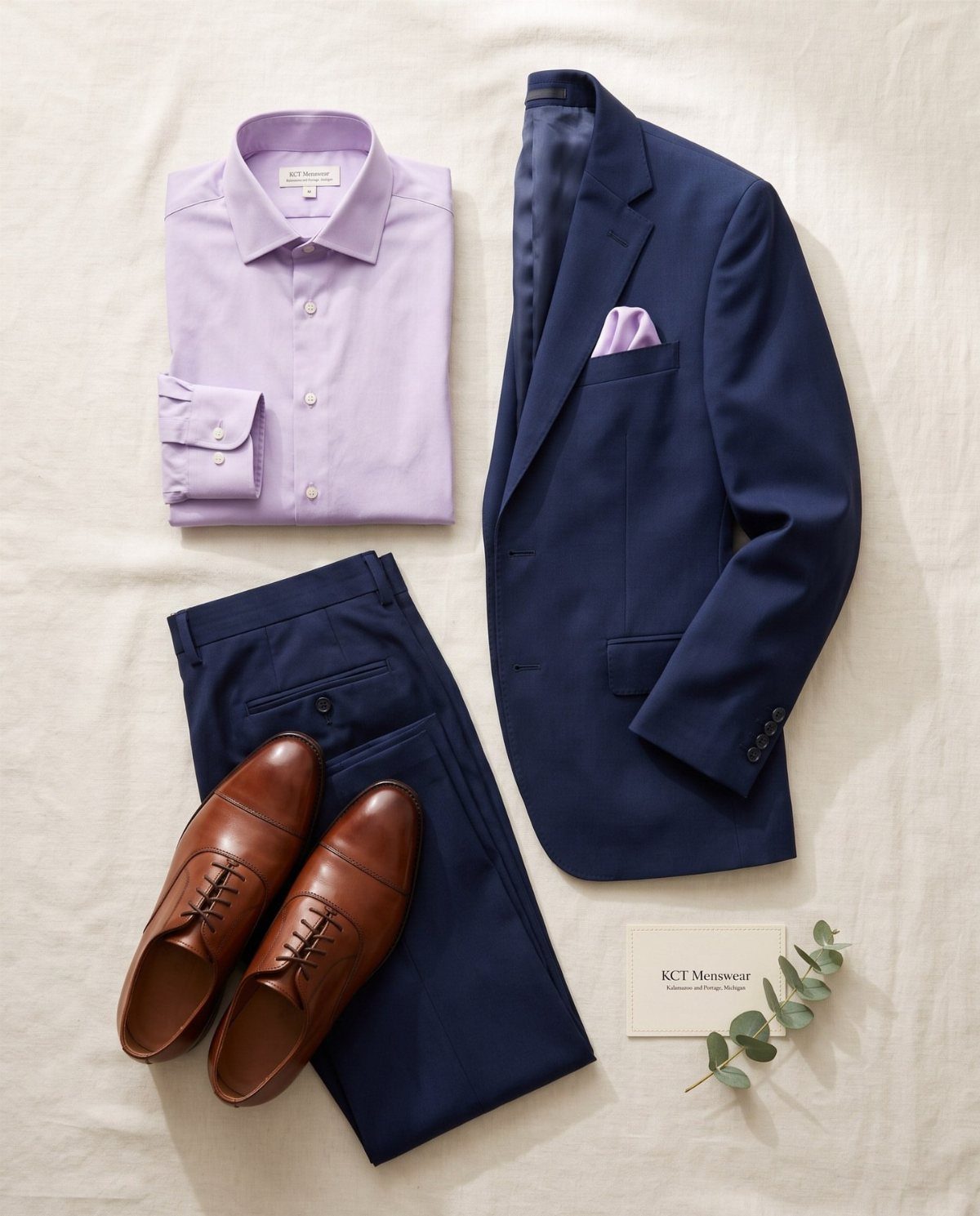 Navy blue suit with a lilac purple shirt and brown leather shoes.