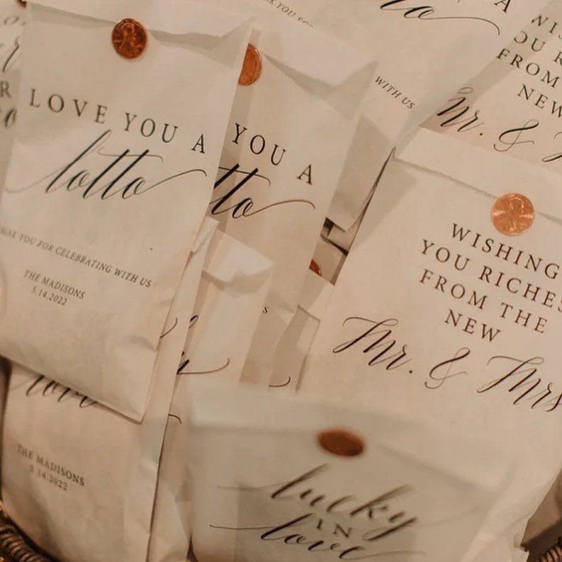 White wedding favor envelopes with gold seals and lottery themed romantic text