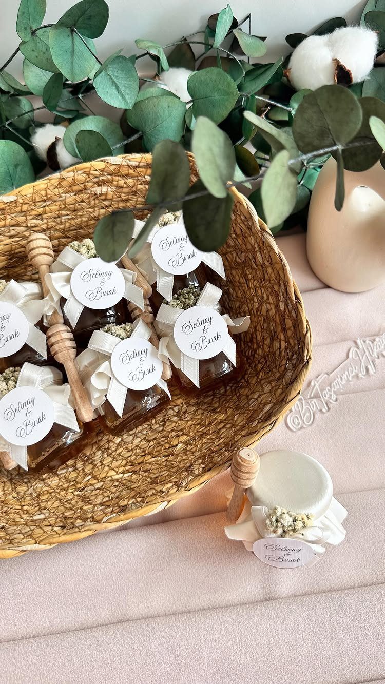 Small honey jars with white ribbons and tags in a woven basket