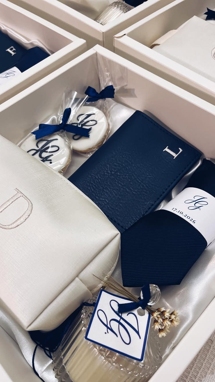 Navy blue and white wedding gift box with personalized accessories and cookies.