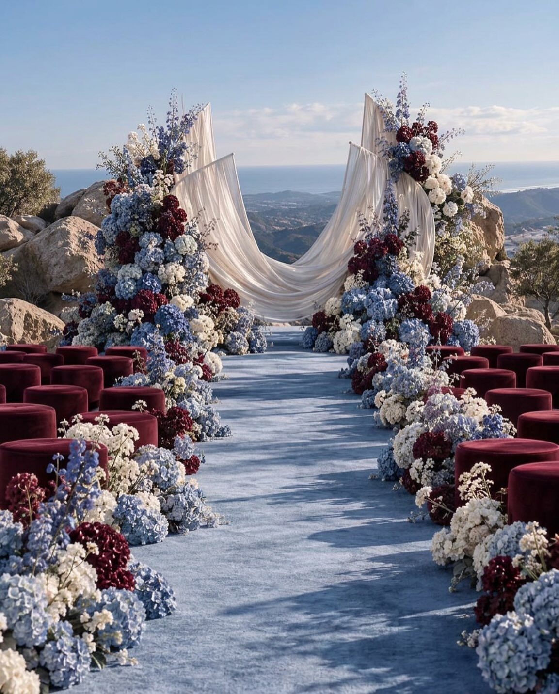 Navy blue carpet aisle with burgundy velvet seats and navy and burgundy floral arrangements.