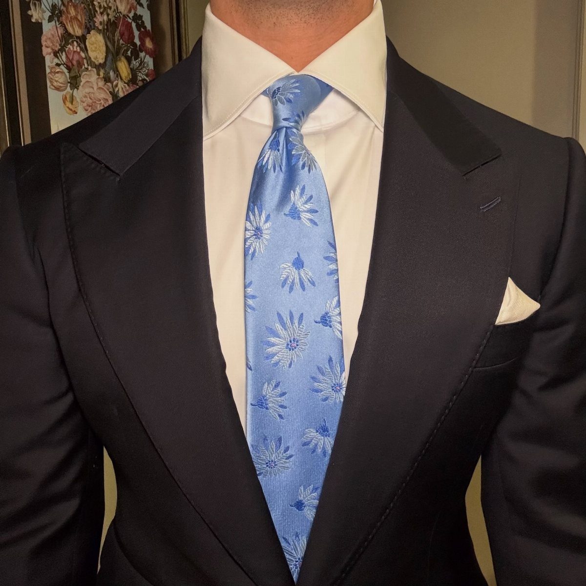 Light blue floral skinny tie paired with a navy blue suit and white shirt