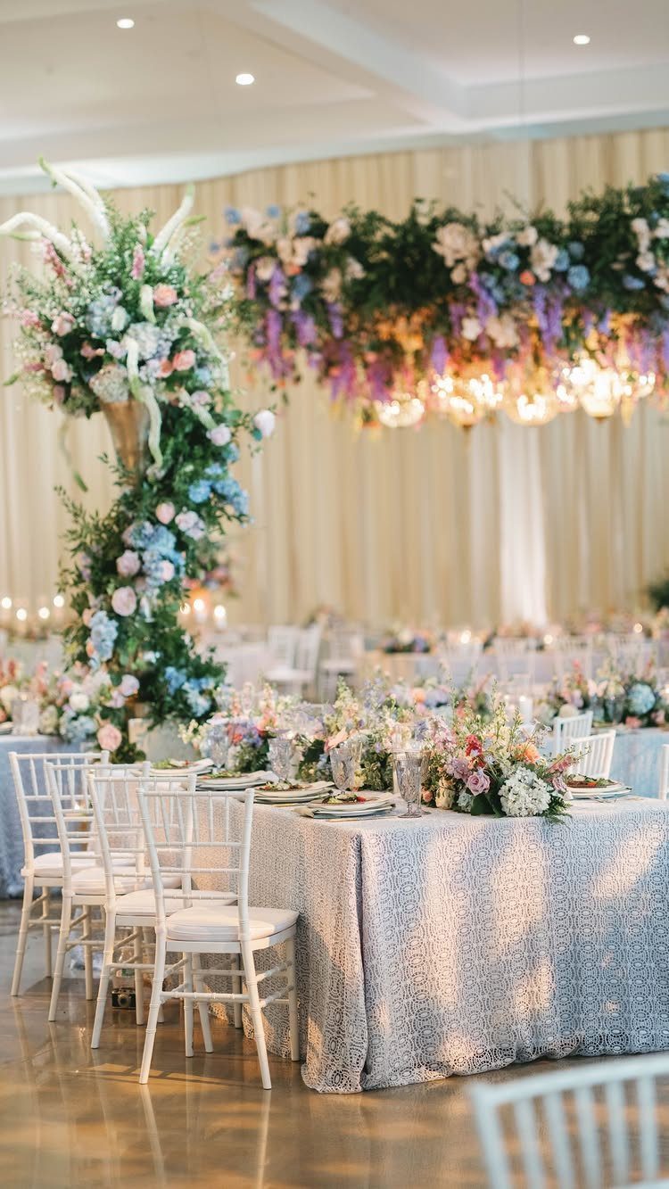 Wedding table with silver sequin cloth and pastel floral arrangements in a bright venue