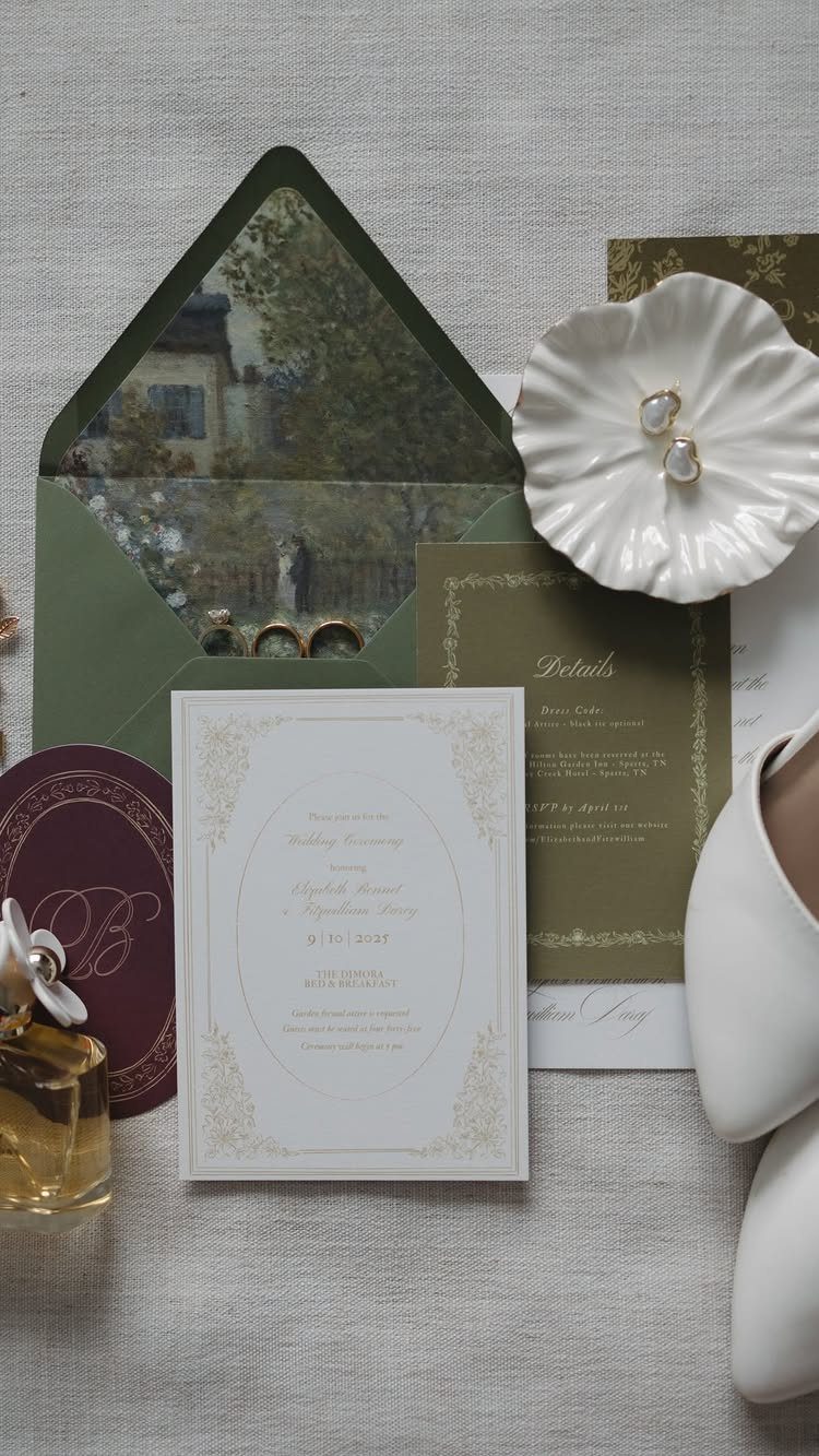 Wedding invitation suite with green and burgundy stationery, gold accents, and floral accessories.