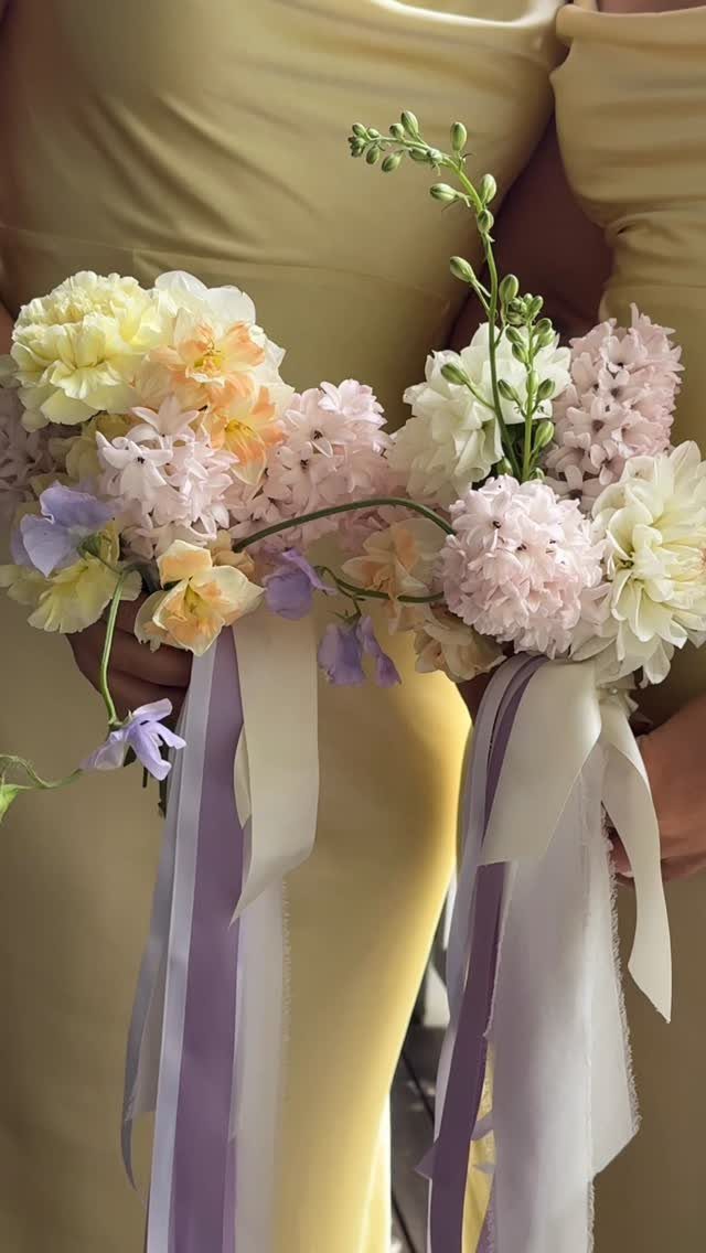 Yellow dress and bouquets of purple and yellow flowers with flowing ribbons.