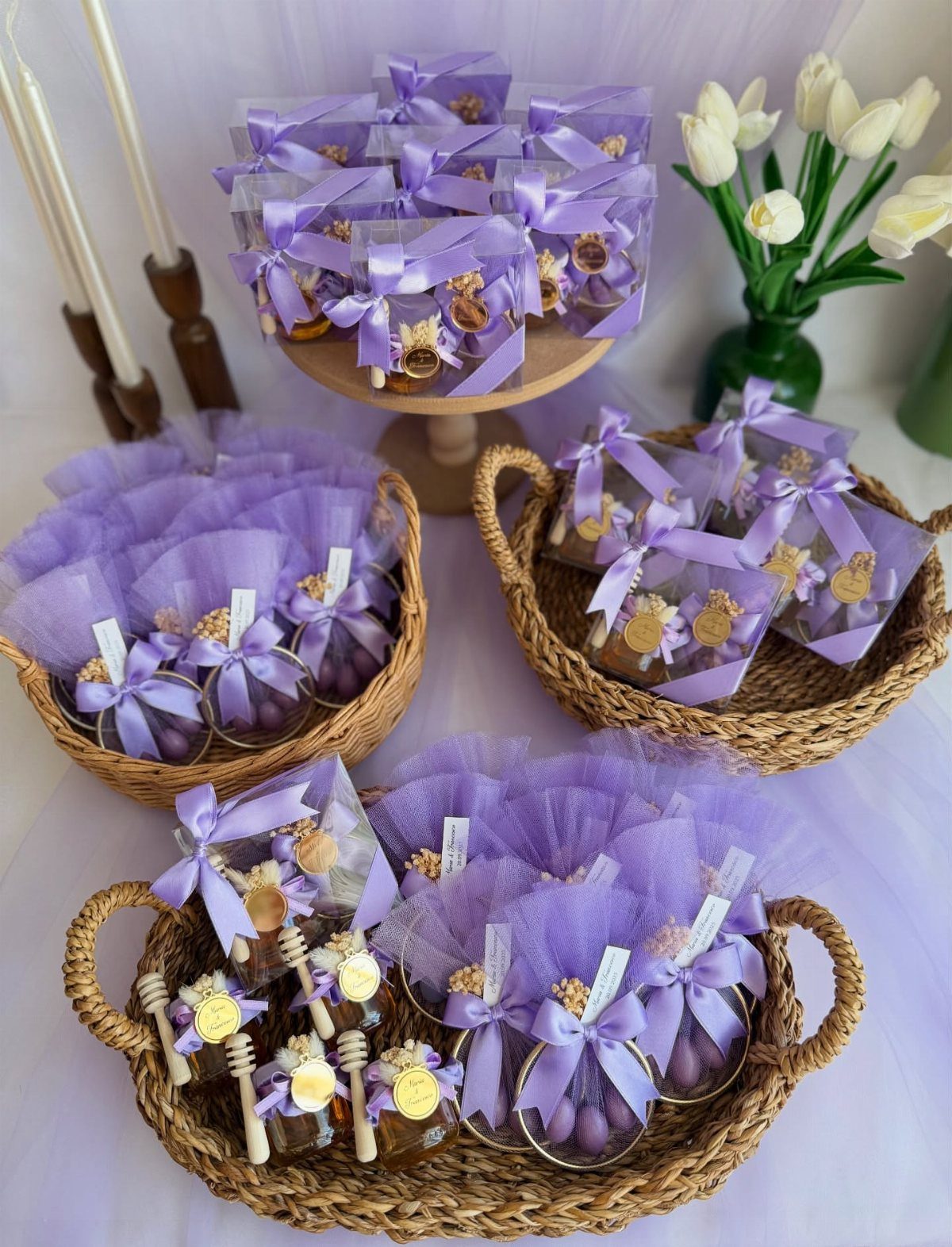 Small honey jars and purple treats wrapped in purple tulle and yellow ribbons.