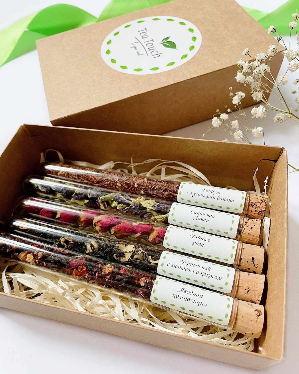 Tea sampler set with five glass tubes of dried tea in a cardboard box