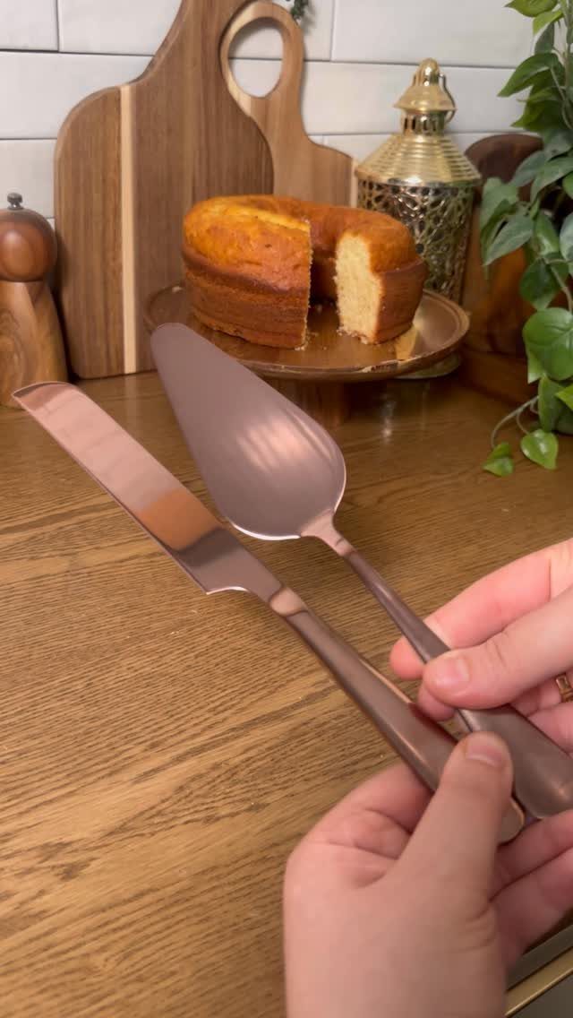 Rose gold cake server and knife held over a sliced cake on a table