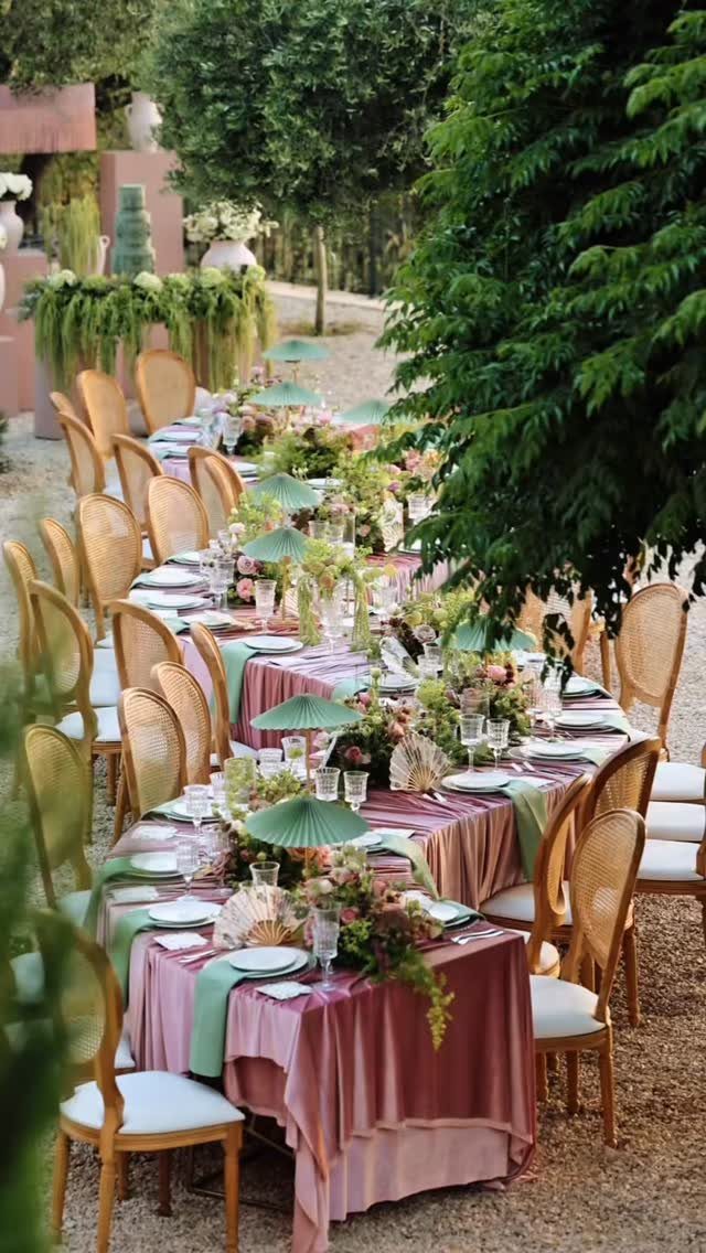 Outdoor wedding table with dusty pink linens, sage green runners, and floral arrangements.