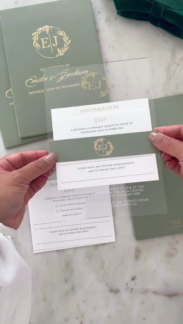 Sage green wedding invitations with gold foil lettering on a white marble background