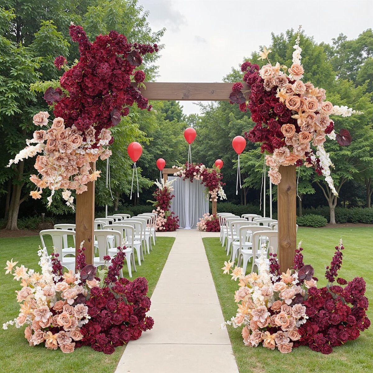 Wooden wedding arch adorned with burgundy and peach roses over a white aisle.