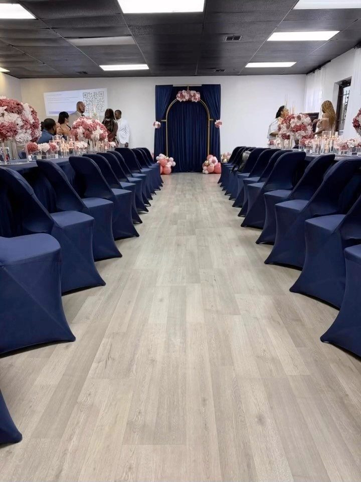 Navy blue chairs and backdrop with blush pink flowers in an event space.