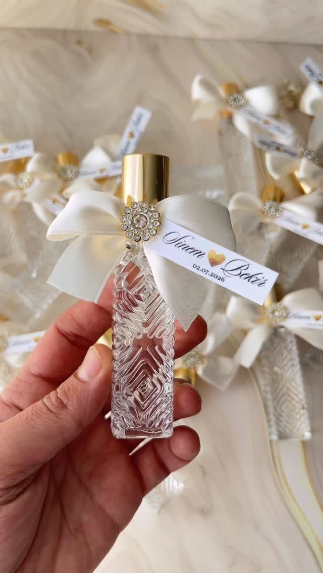 Small textured glass favor bottle with white bow and personalized name tag