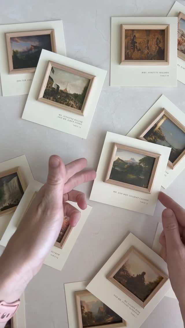Miniature landscape paintings in small wooden frames mounted on white cards.
