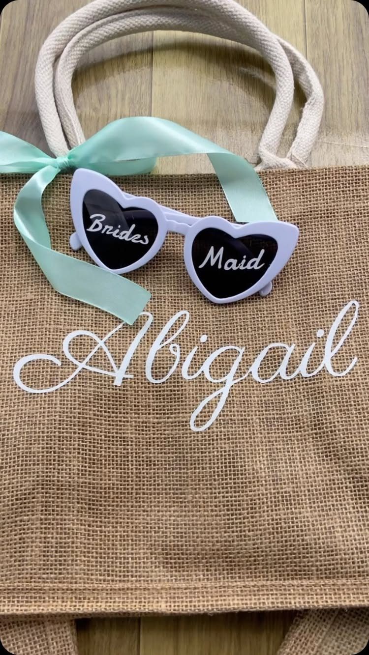 Burlap tote bag personalized with the name Abigail and bridesmaid heart sunglasses.