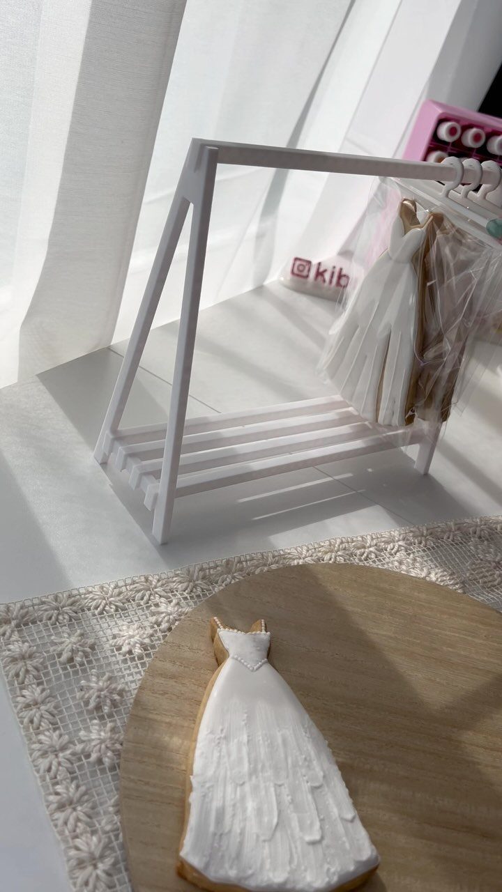 Wedding dress shaped cookie with white icing on a wooden board