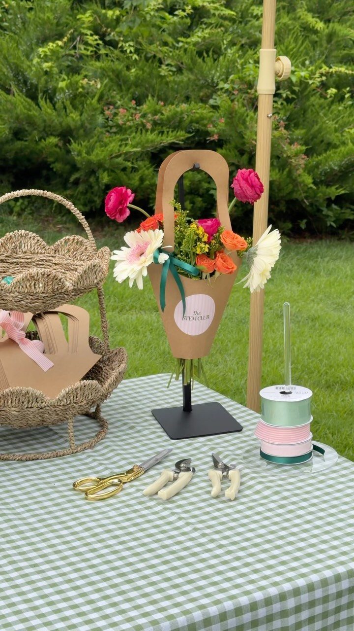 Flower bouquet station with a small arrangement in a paper cone on checkered tablecloth