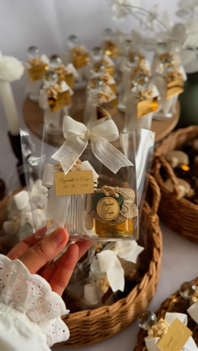 Small honey jars with white bows and personalized tags in wicker baskets
