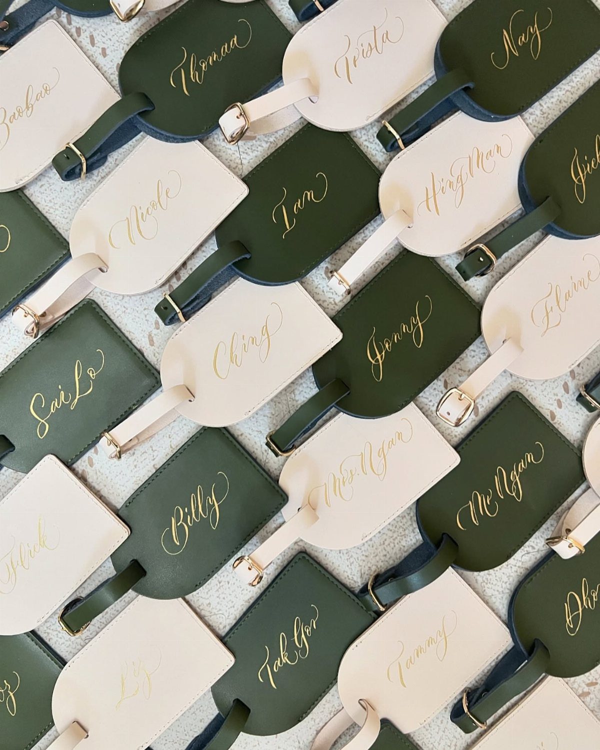 Leather luggage tags in green and cream with gold calligraphed names.