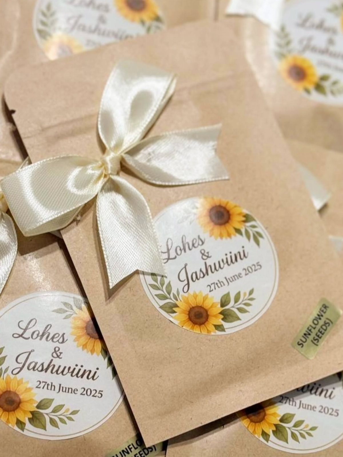 Brown kraft seed packets with sunflower labels and white satin bows for weddings.