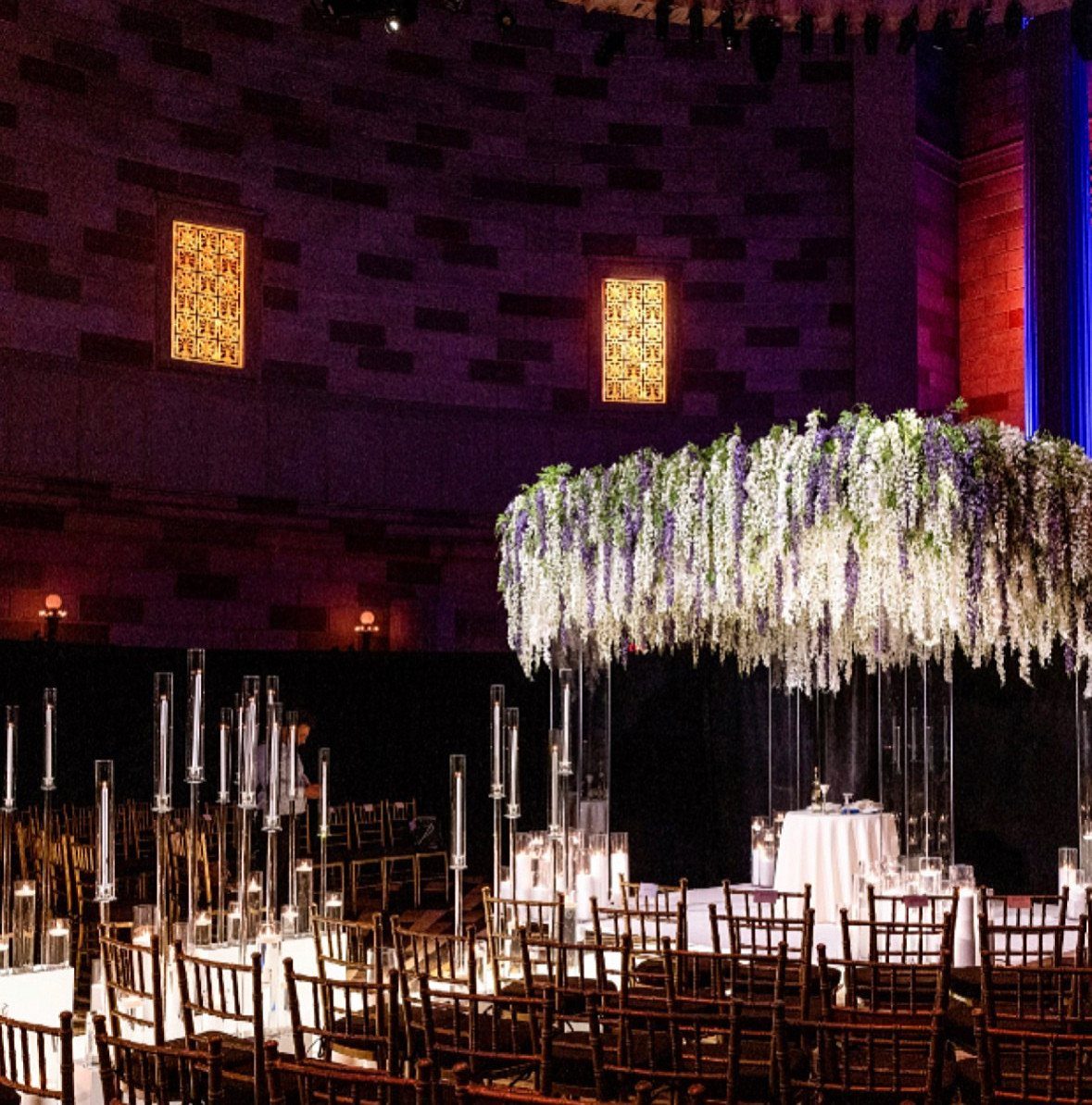 Suspended white and purple wisteria floral installation hanging over a wedding ceremony altar.