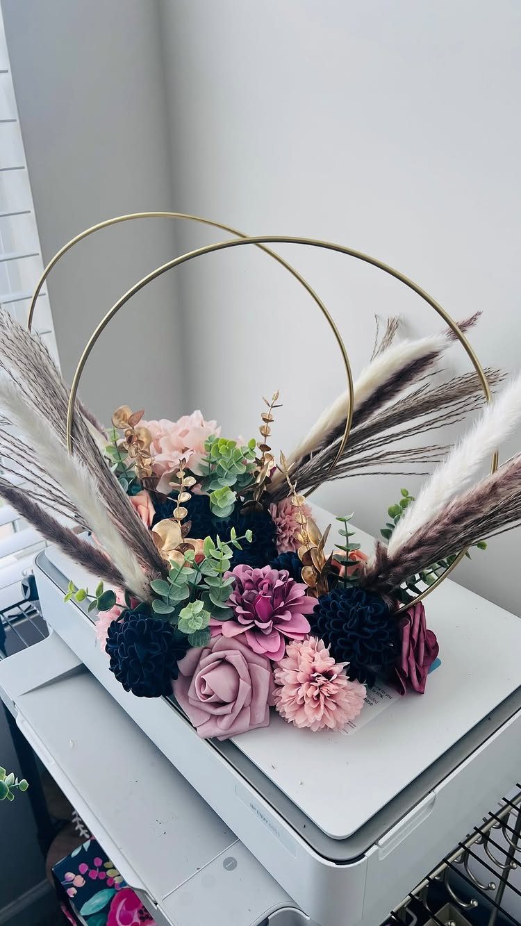 Navy blue and blush pink floral arrangement with gold hoops and pampas grass.