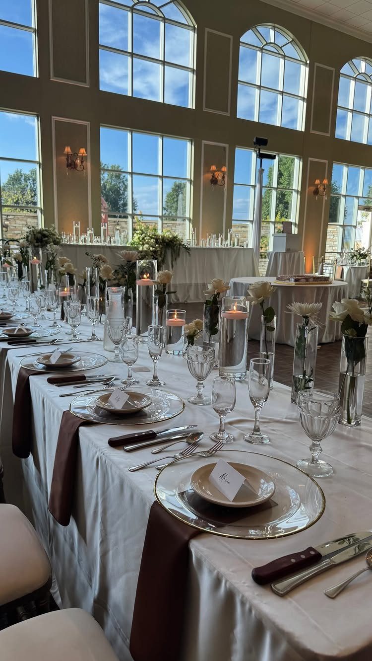 Wedding banquet table with white linens, espresso brown runners, and ivory plateware.
